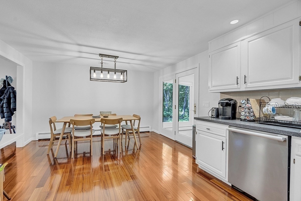 113 Townsend Road Shirley, MA 01464 - Photo 12 of 30 a kitchen with granite countertop a table chairs stove and white cabinets