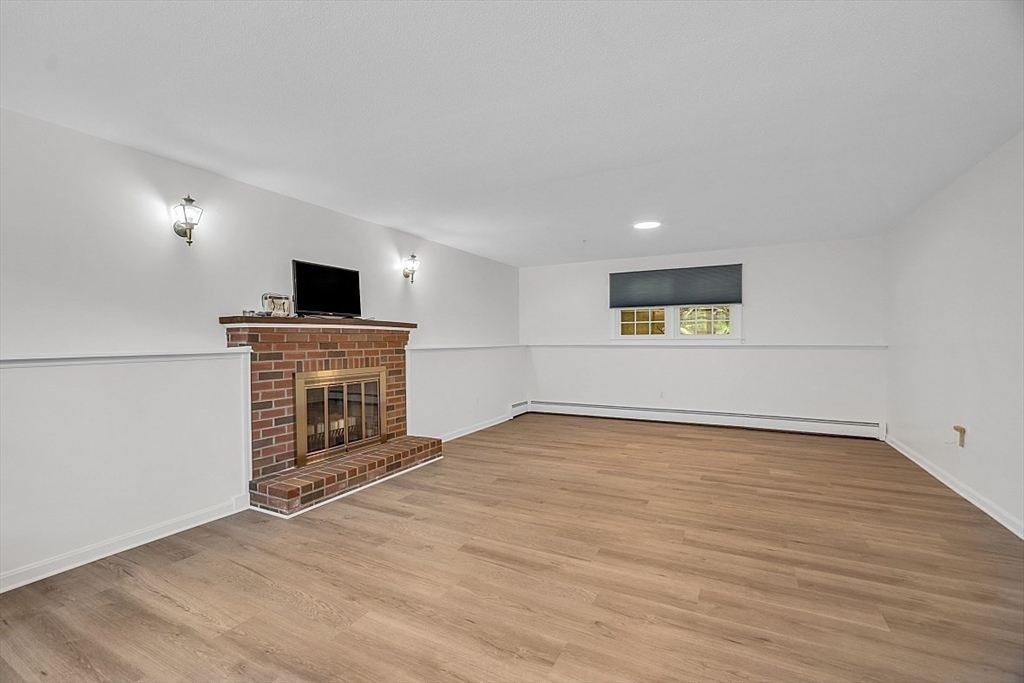113 Townsend Road Shirley, MA 01464 - Photo 22 of 30 a view of empty room with a fireplace and wooden floor