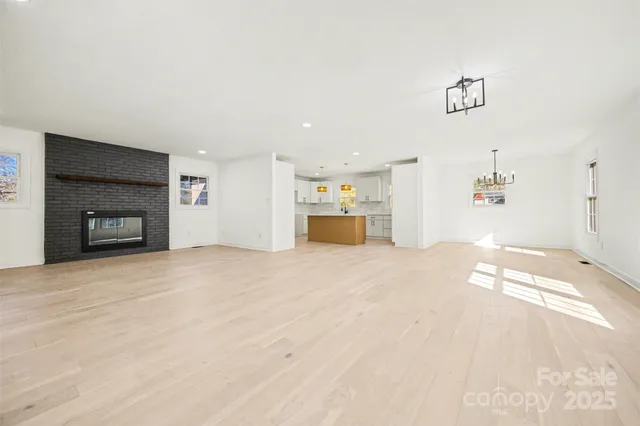 a view of empty room with wooden floor and fireplace