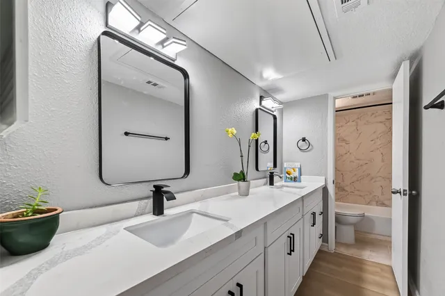 a bathroom with a double vanity sink mirror and