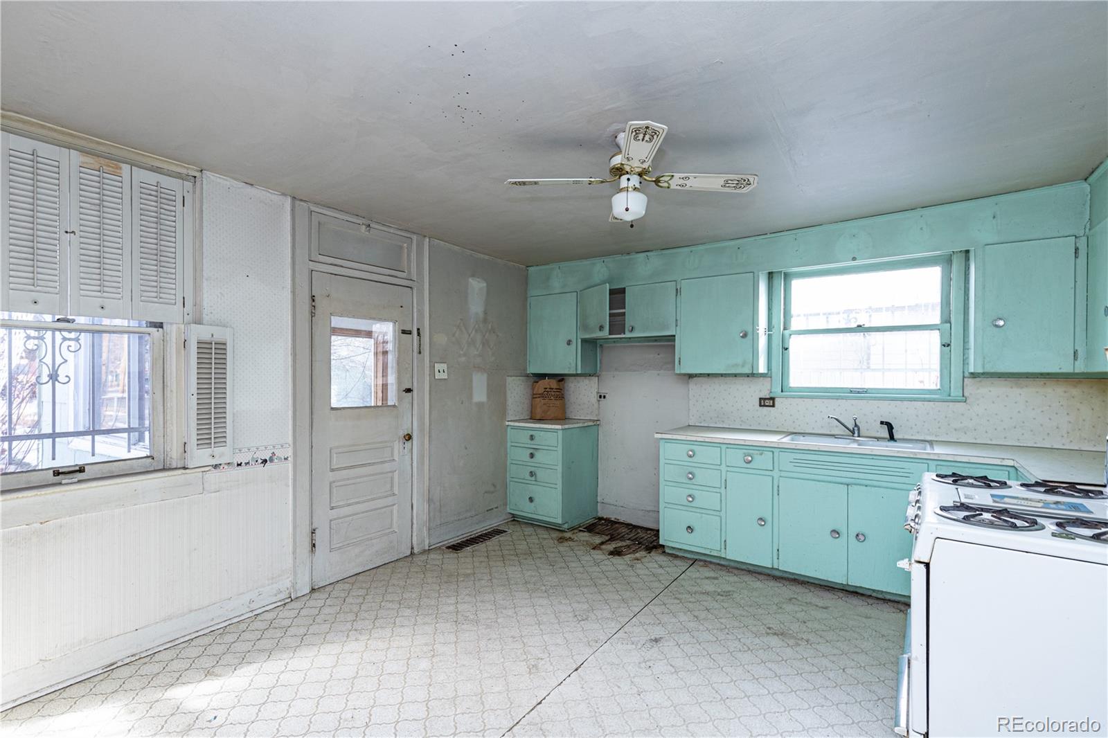 4494 Meade Street Denver, CO 80211 - Photo 11 of 24 a kitchen that has a lot of cabinets in it and wooden floors