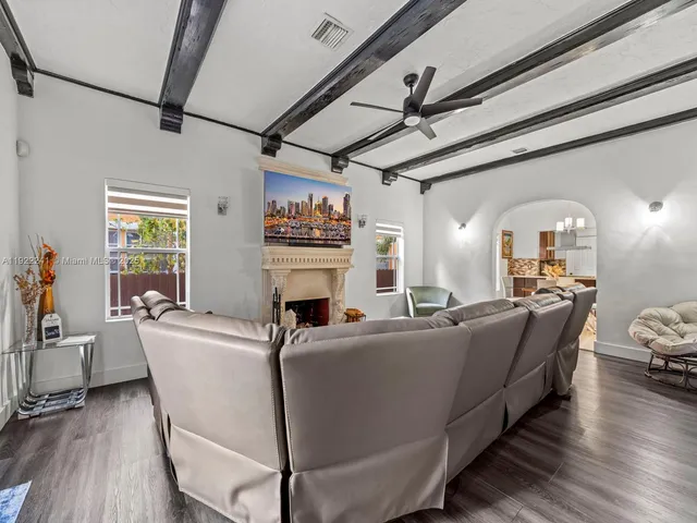 a living room with furniture a fireplace and wooden floor
