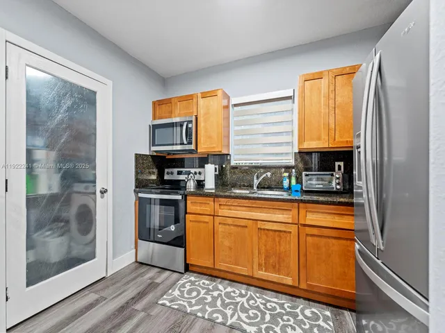a kitchen with stainless steel appliances granite countertop a refrigerator and a sink