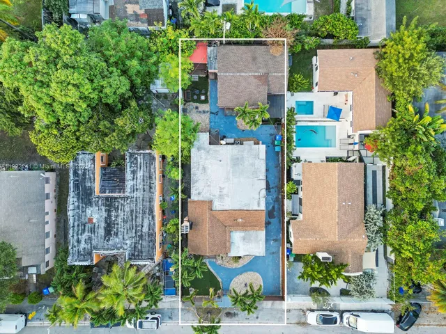 an aerial view of a house with outdoor space and trees all around