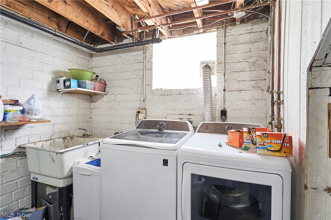 136 Smith Avenue Northwest Canton, OH 44708 - Photo 12 of 19 Laundry area featuring white painted brick walls and exposed wood ceiling joists