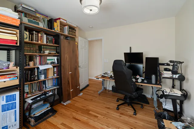 a view of a workspace with furniture and a book shelf