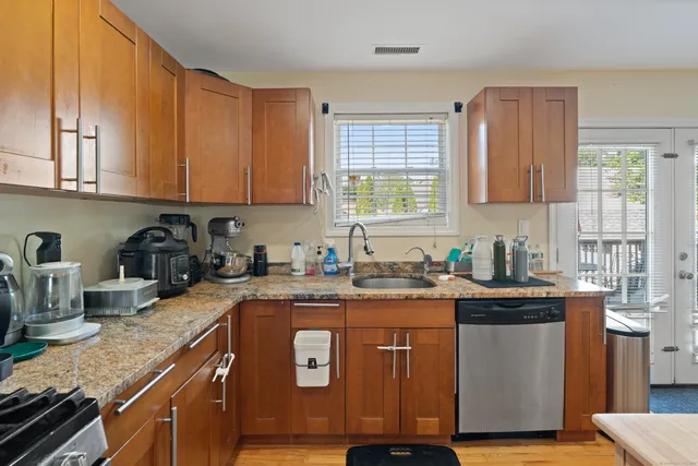 a kitchen with granite countertop a sink stove and cabinets