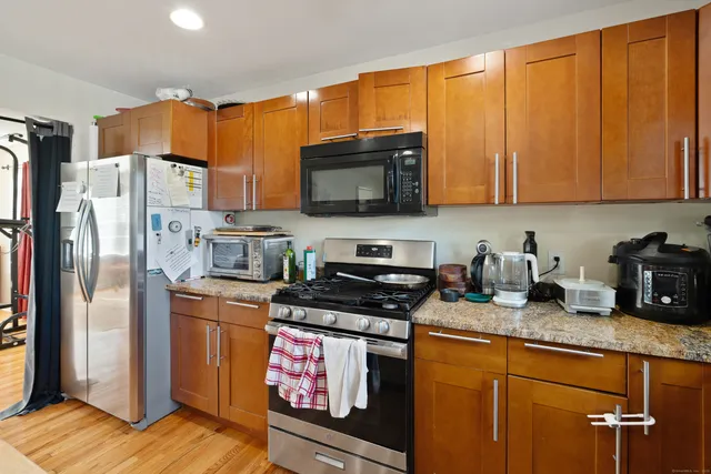 a kitchen with stainless steel appliances granite countertop a refrigerator stove top oven a sink and dishwasher