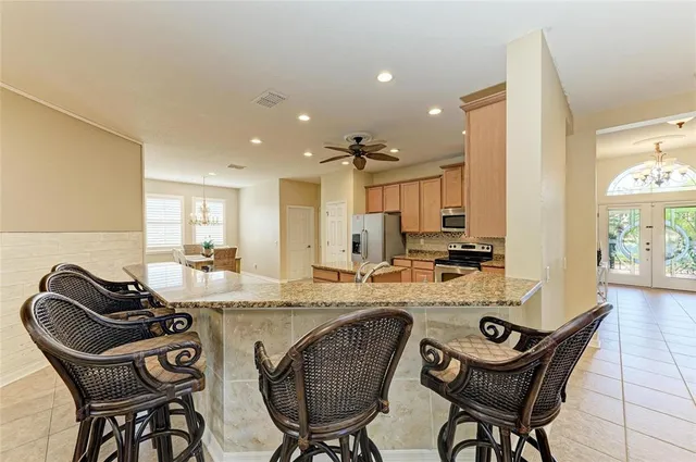 a kitchen with stainless steel appliances granite countertop a stove refrigerator sink and microwave