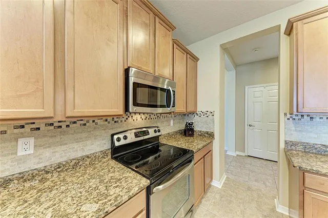a dining room with furniture a chandelier and kitchen view