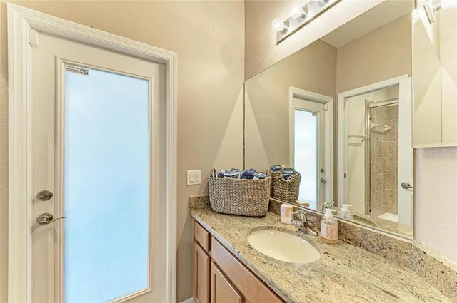a bathroom with a granite countertop sink a toilet and shower