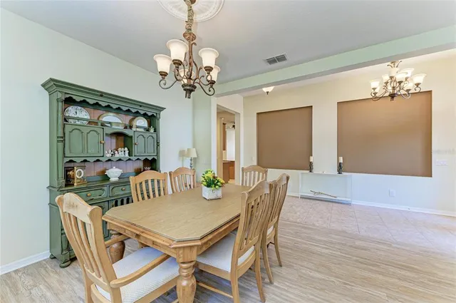 a view of a dining room with furniture a chandelier and wooden floor