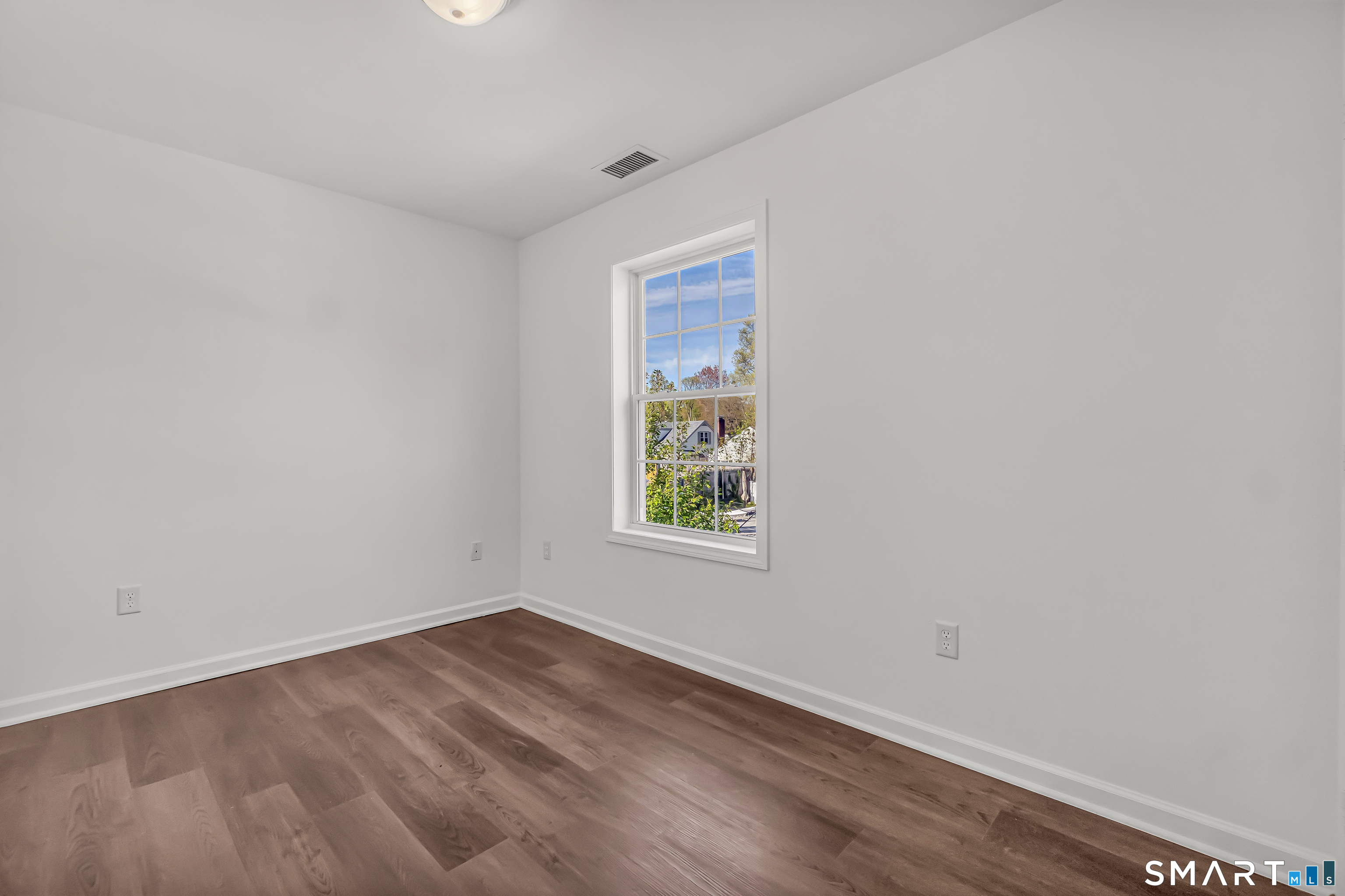 1770 Stratfield Road Fairfield, CT 06825 - Photo 26 of 40 a view of an empty room with wooden floor and a window
