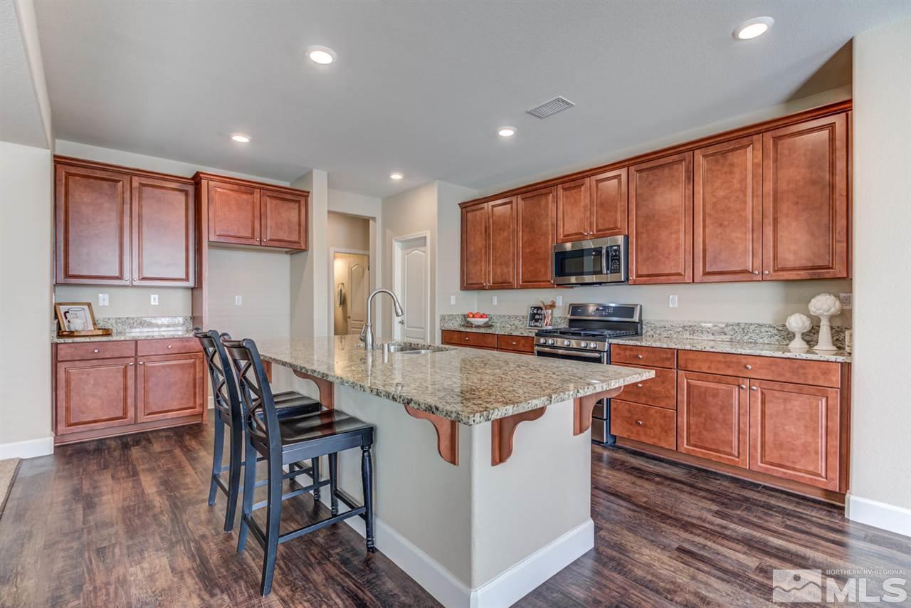 10290 Culiacan Pass Trail Reno, NV 89521 - Photo 10 of 23 a kitchen with stainless steel appliances granite countertop wooden cabinets a stove top oven a sink and dishwasher with wooden floor