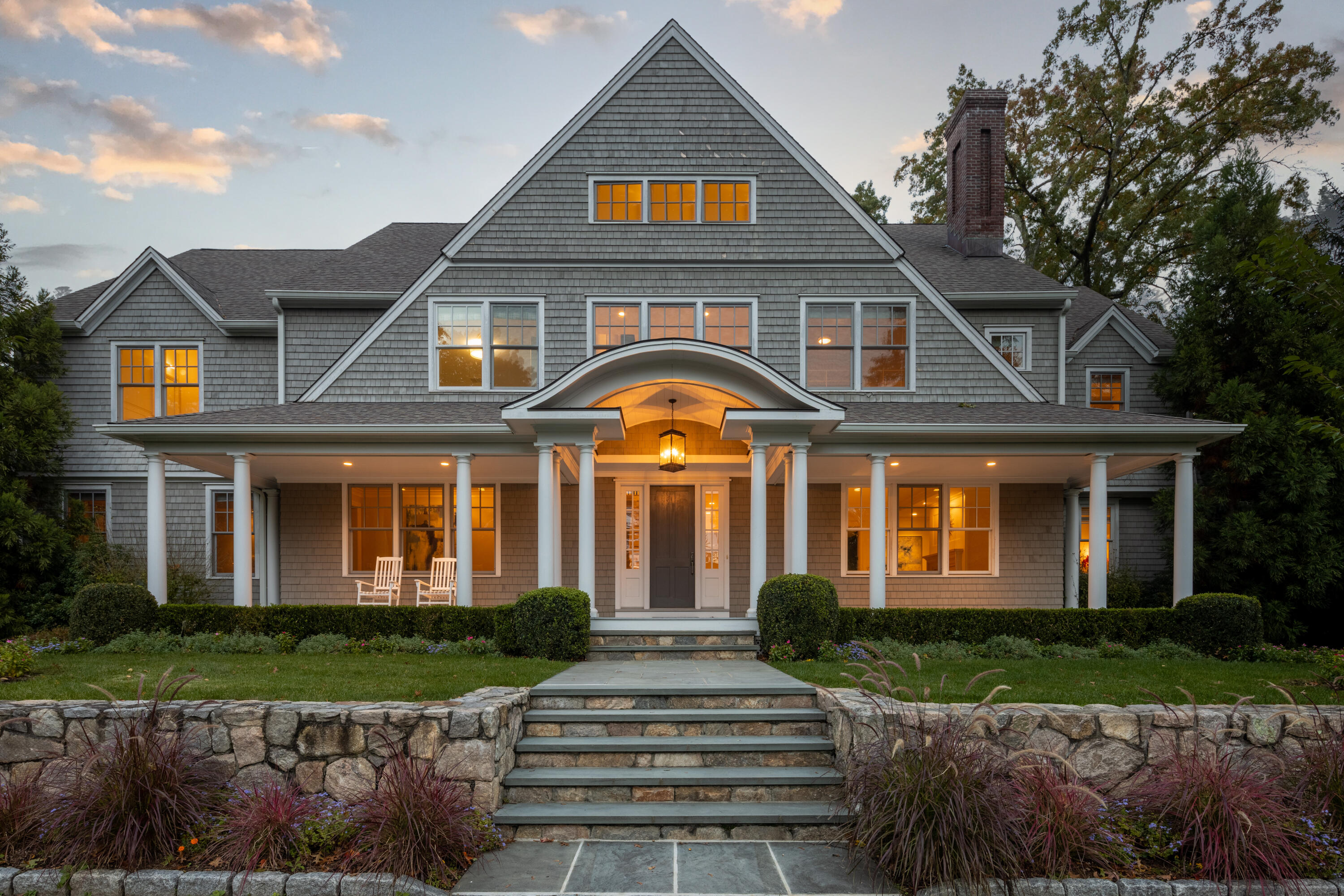 a front view of a house with a yard and potted plants