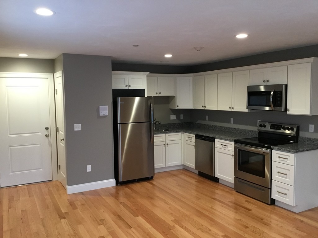 83 D Maple Avenue, Unit D Rutland, MA 01543 - Photo 3 of 12 a kitchen with granite countertop a refrigerator and a stove top oven