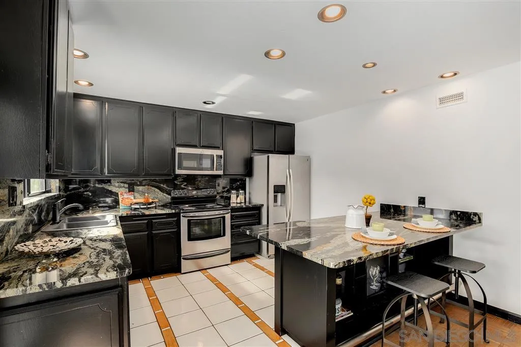 2033 Village Wood Road Encinitas, CA 92024 - Photo 14 of 25 a kitchen with a sink appliances and cabinets