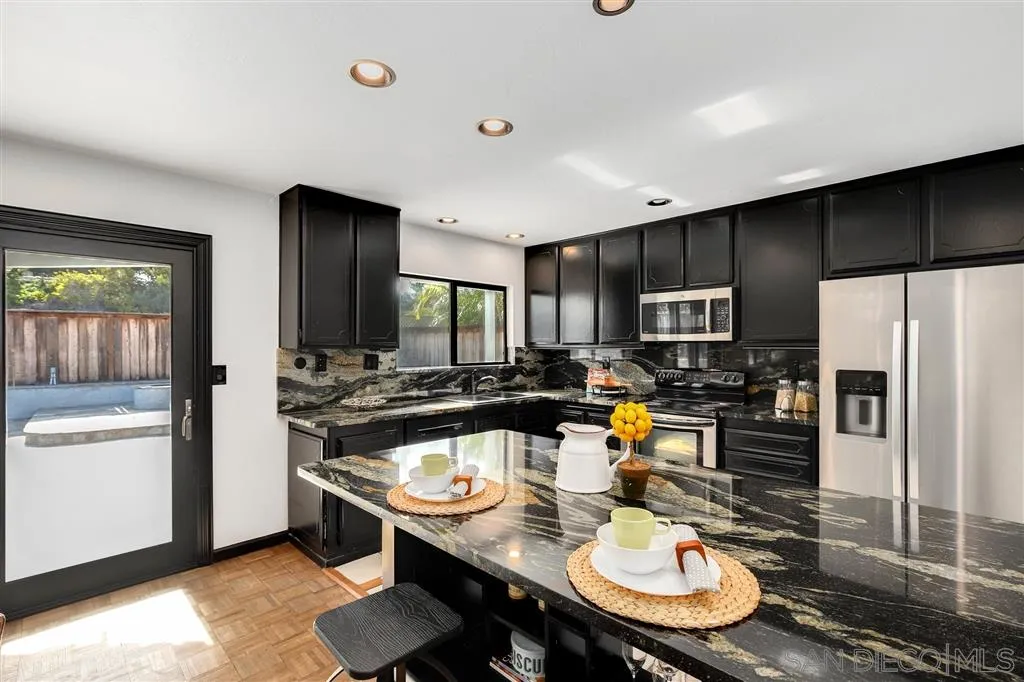 2033 Village Wood Road Encinitas, CA 92024 - Photo 15 of 25 a kitchen with a sink a stove and chairs