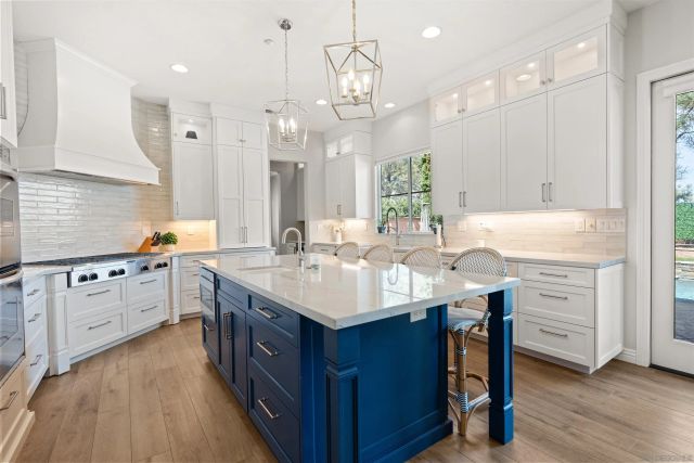 a kitchen with kitchen island granite countertop a sink cabinets and wooden floor