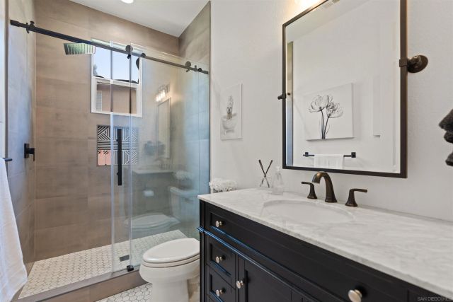 a bathroom with a granite countertop sink toilet and shower