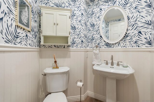 a bathroom with a sink and mirror with toilet