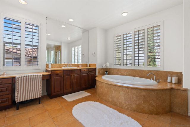 a spacious bathroom with a tub double sink window and mirror
