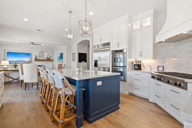 a kitchen with stainless steel appliances kitchen island granite countertop a stove a sink and a refrigerator