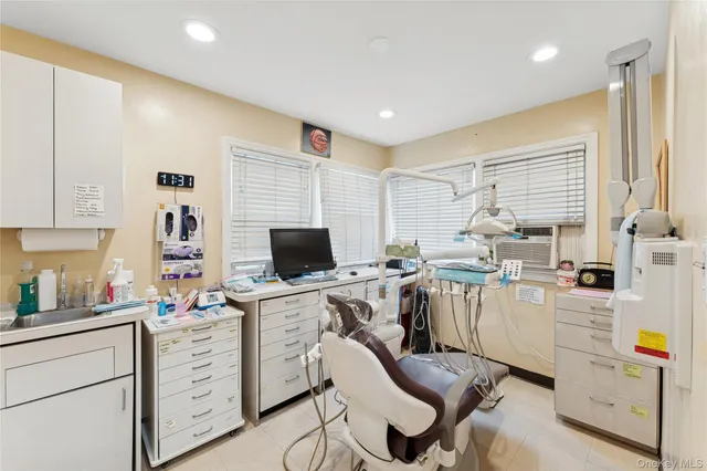 a view of a workspace with furniture and a window