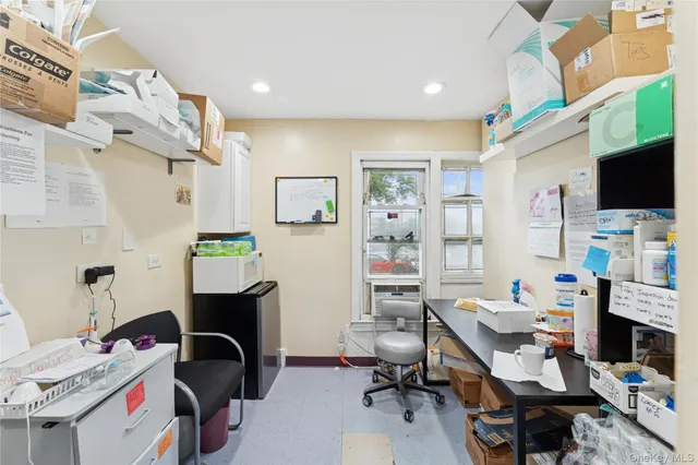 a view of a workspace with furniture and a window