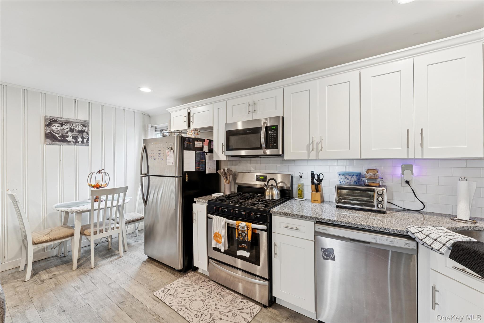 5 Seaton Gate Valley Stream, NY 11580 - Photo 26 of 36 a kitchen with stainless steel appliances granite countertop a stove top oven a refrigerator a sink and white cabinets