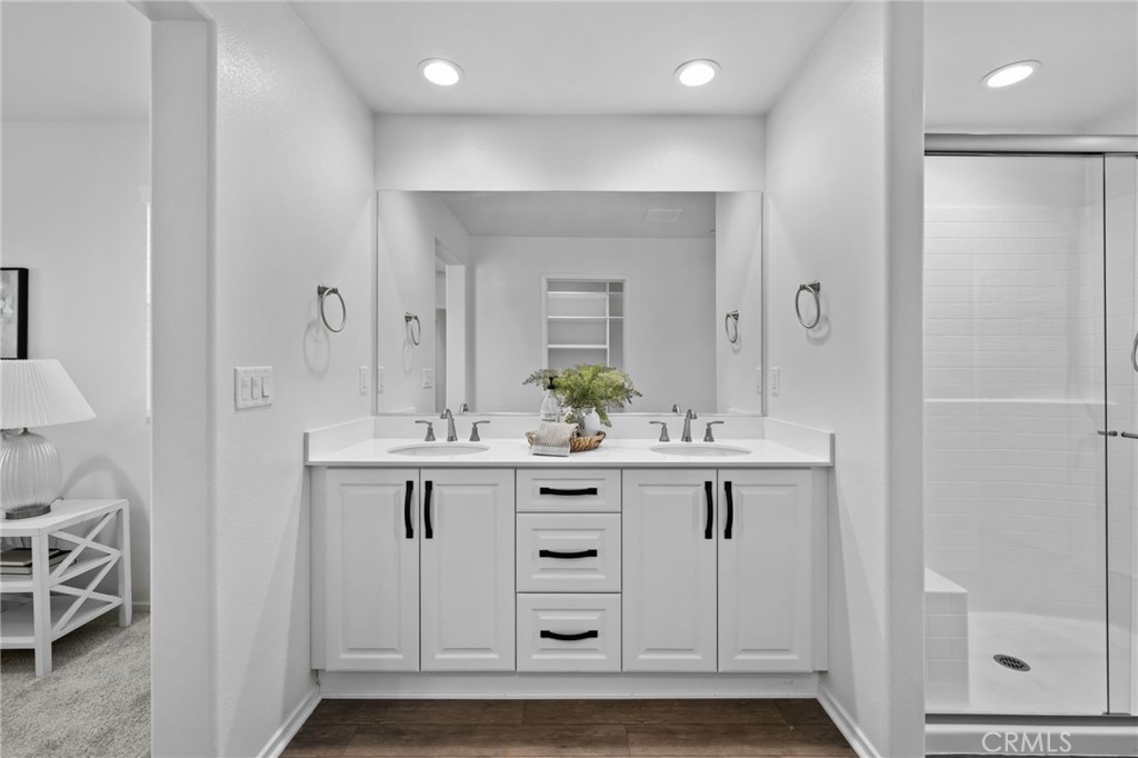 24085 Midvale Court Corona, CA 92883 - Photo 23 of 56 a bathroom with a sink a mirror a vanity and a shower
