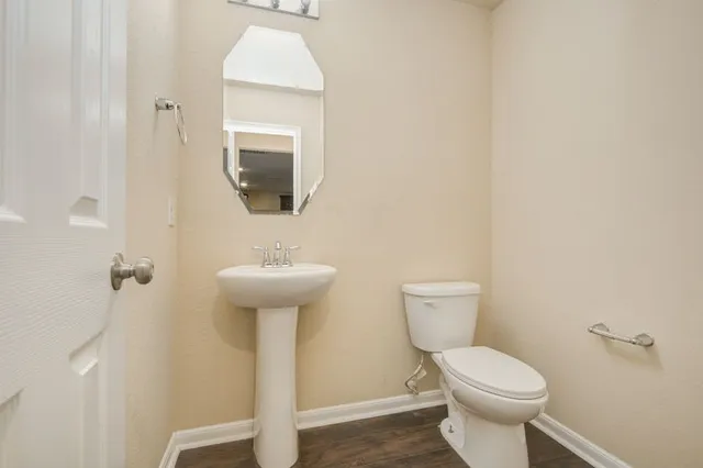 a bathroom with a toilet a sink and mirror