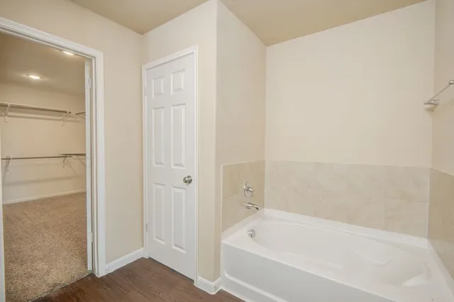 a white bath tub sitting next to a shower