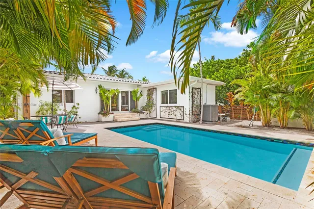 a view of a house with pool and chairs