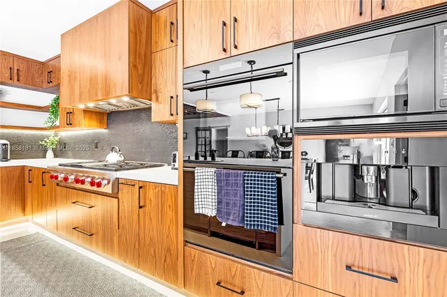a kitchen with stainless steel appliances granite countertop a stove and a microwave