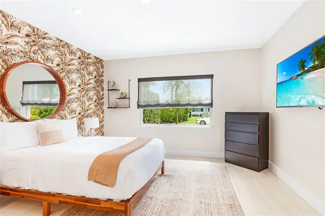 a bedroom with a bed and a dresser with mirror