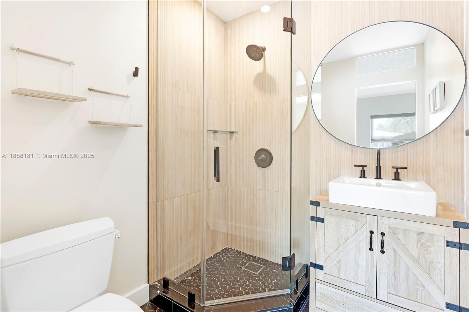 9065 Emerson Avenue Surfside, FL 33154 - Photo 37 of 50 a bathroom with a sink a toilet and a mirror