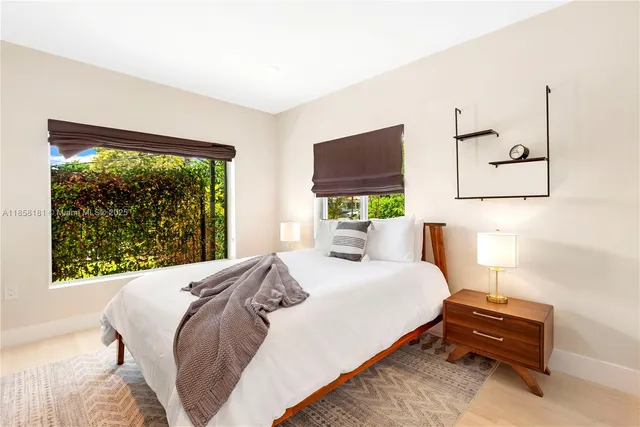 a bedroom with a bed window and a flat screen tv