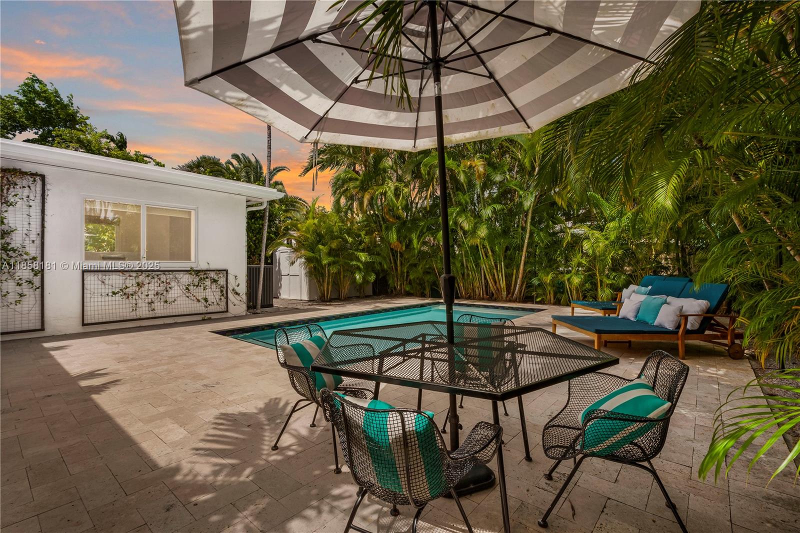 9065 Emerson Avenue Surfside, FL 33154 - Photo 46 of 50 a patio with a table and chairs under an umbrella