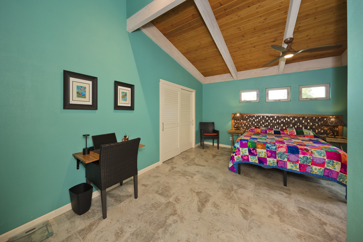 12-7002 Ho'Eunalu Street Pahoa, HI 96778 - Photo 18 of 26 a bedroom with a bed and a chair