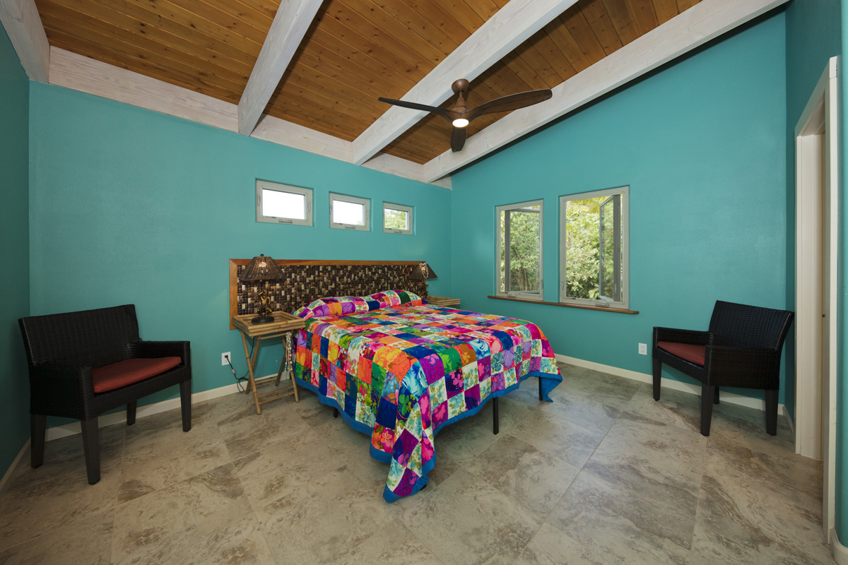 12-7002 Ho'Eunalu Street Pahoa, HI 96778 - Photo 19 of 26 a bedroom with a bed and a chair
