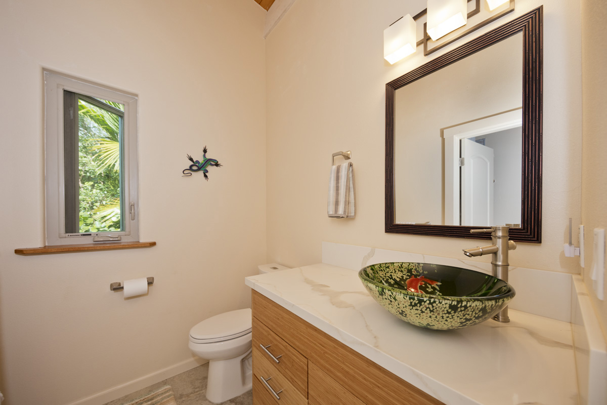 12-7002 Ho'Eunalu Street Pahoa, HI 96778 - Photo 21 of 26 a bathroom with a sink mirror vanity and toilet