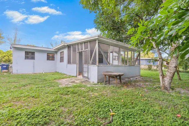 a view of a house with backyard and a tree