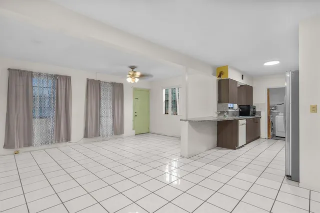 a large white kitchen with a sink and cabinets