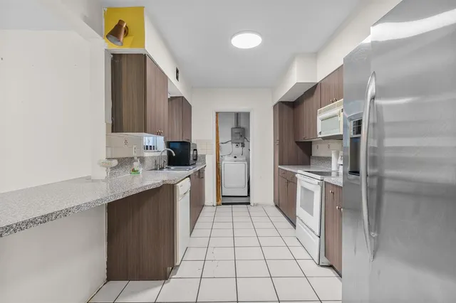 a kitchen with stainless steel appliances granite countertop a refrigerator and a stove top oven