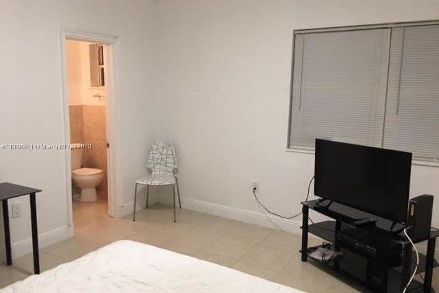 Normandy Isle Miami Beach, FL 33141 - Photo 6 of 13 a living room with furniture and a flat screen tv