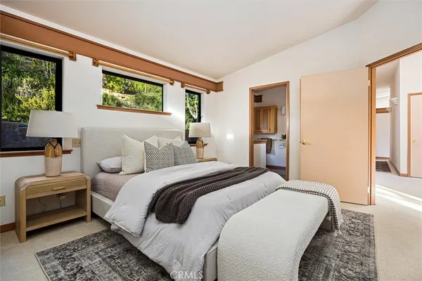 a spacious bedroom with a bed and wooden floor