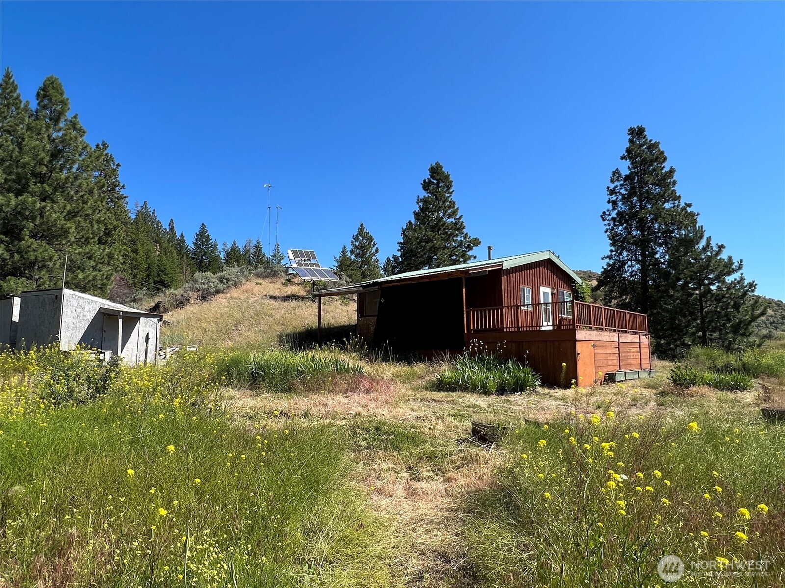 113 Eagles Bluff Road Oroville, WA 98844 - Photo 3 of 33 a yellow house with green field in front of it