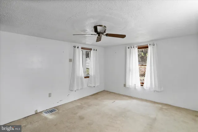 a view of empty room with ceiling fan