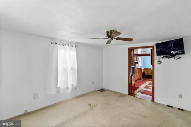 an empty room with closet area and fan
